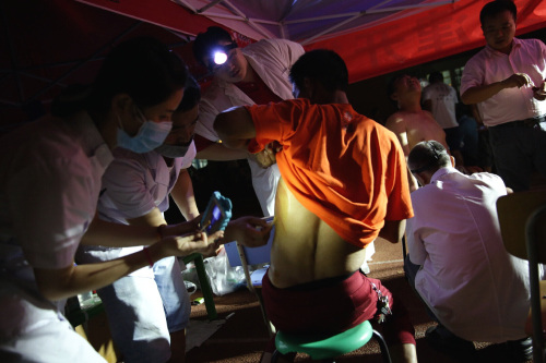 Doctors tend to the wounded in a makeshift clinic located within the No. 2 Elementary School of the Binhai New District Development Zone in Tianjin on August 13 (XINHUA) Doctors tend to the wounded in a makeshift clinic located within the No. 2 Elementary School of the Binhai New District Development Zone in Tianjin on August 13 (XINHUA)