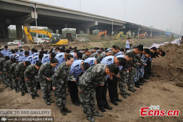 Rescue workers hold three-minute silence on the seventh day since the blasts rocked a warehouse storing hazardous chemicals in Tianjin Binhai New Area, Aug 18. (Photo/CFP)