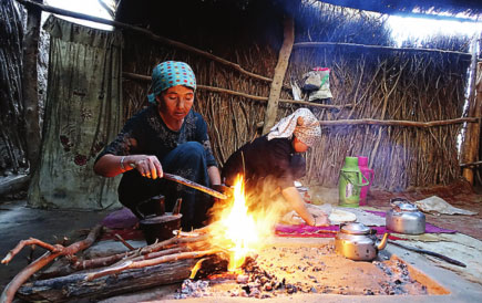 Women make a fire to cook in Daiyabuli township. Women make a fire to cook in Daiyabuli township.