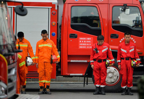 Firefighters hold three-minute silence at a ceremony to mark the seventh day since the blasts rocked a warehouse storing hazardous chemicals in Tianjin Binhai New Area, Aug 18. (Photo/Xinhua)