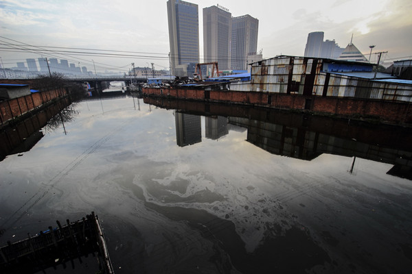 A river polluted by waste oil glimmers in Shaoxing, Zhejiang province, in March. (Photo by Li Ruichang/China Daily) A river polluted by waste oil glimmers in Shaoxing, Zhejiang province, in March. (Photo by Li Ruichang/China Daily)