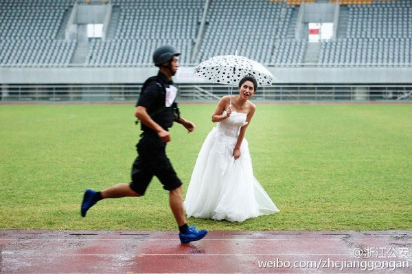 Dressed in her wedding gown and holding an umbrella against the rain, the bride cheers her husband-to-be in the rain. (Photo/Weibo.com) Dressed in her wedding gown and holding an umbrella against the rain, the bride cheers her husband-to-be in the rain. (Photo/Weibo.com)