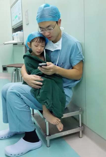 Dr. Shi Zhuo comforts a little toddler patient with a cartoon app on his cell phone before heart surgery in Hangzhou, Zhejiang province, Sept 18, 2015. (Photo/weibo.com) Dr. Shi Zhuo comforts a little toddler patient with a cartoon app on his cell phone before heart surgery in Hangzhou, Zhejiang province, Sept 18, 2015. (Photo/weibo.com)