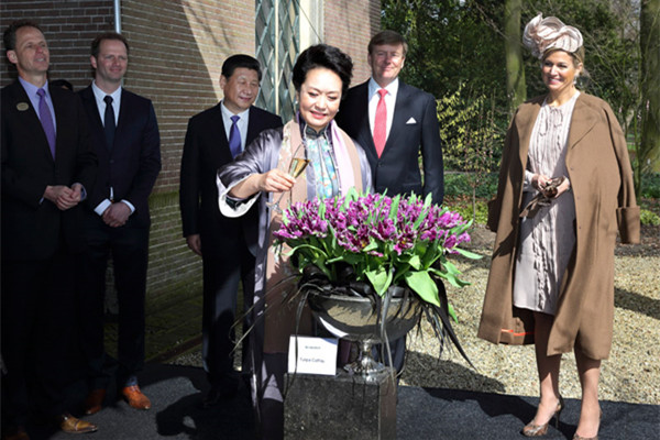 Peng Liyuan (C), wife of China's President Xi Jinping (L), baptizes the tulip Cathay on the second day of their state visit to the Netherlands March 23, 2014. (Photo/Xinhua) Peng Liyuan (C), wife of China's President Xi Jinping (L), baptizes the tulip Cathay on the second day of their state visit to the Netherlands March 23, 2014. (Photo/Xinhua)