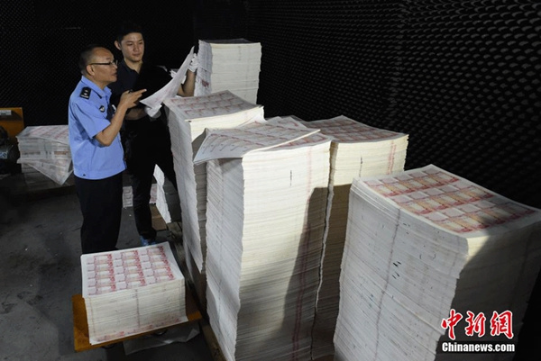 Police officers in Huizhou in South China's Guangdong province examine the paper used for counterfeiting 100-yuan banknotes on September 24, 2015. (Photo/chinanews.com) Police officers in Huizhou in South China's Guangdong province examine the paper used for counterfeiting 100-yuan banknotes on September 24, 2015. (Photo/chinanews.com)