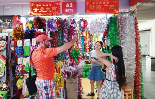 A businessman (L) selects products in Yiwu for sale at Christmas. Made in China gives Americans a Merry Christmas. (Photo/China Daily) A businessman (L) selects products in Yiwu for sale at Christmas. Made in China gives Americans a Merry Christmas. (Photo/China Daily)