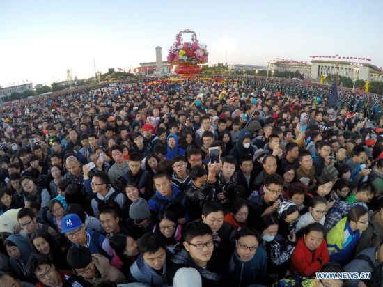 People gather to watch a national flag-raising ceremony marking the 66th anniversary of the founding of the People's Republic of China on the National Day at the Tiananmen Square in Beijing, capital of China, Oct. 1, 2015. (Xinhua/Xing Guangli) People gather to watch a national flag-raising ceremony marking the 66th anniversary of the founding of the People's Republic of China on the National Day at the Tiananmen Square in Beijing, capital of China, Oct. 1, 2015. (Xinhua/Xing Guangli)