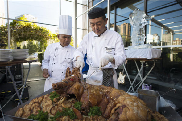 Chefs wow the opening-night crowd with a roast suckling pig made specially for the occasion. (Photo/Provided To China Daily) Chefs wow the opening-night crowd with a roast suckling pig made specially for the occasion. (Photo/Provided To China Daily)