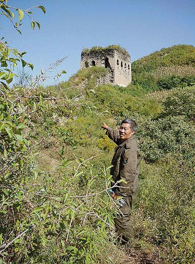 One protector of the Great Wall in Funing county, Qinghuangdao city, Heibei province, points to a damaged section of the historical structure. (Photo/China Youth News) One protector of the Great Wall in Funing county, Qinghuangdao city, Heibei province, points to a damaged section of the historical structure. (Photo/China Youth News)