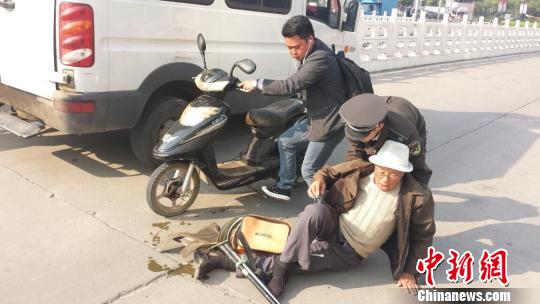 An urban management officer helps an old man to stand up. (File photo/Chinanews.com) An urban management officer helps an old man to stand up. (File photo/Chinanews.com)