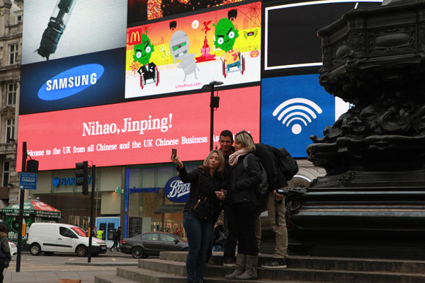 Visitors take picture at Piccadilly Circus, central London, where an electronic screen flashes Nihao, Jinping. (Tuo Yannan/China Daily) Visitors take picture at Piccadilly Circus, central London, where an electronic screen flashes Nihao, Jinping. (Tuo Yannan/China Daily)
