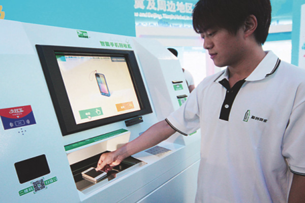 A man operates a machine that is capable of collecting used cellphones for recycling at a low-carbon technology fair in Beijing. (Photo/China Daily) A man operates a machine that is capable of collecting used cellphones for recycling at a low-carbon technology fair in Beijing. (Photo/China Daily)