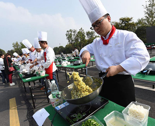 A cook stirs a pan of fried rice. (Photo/Xinhua) A cook stirs a pan of fried rice. (Photo/Xinhua)