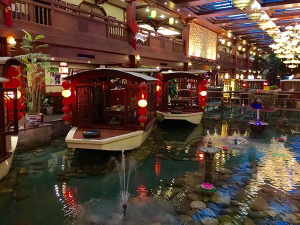Xiaoxiang Jiayu Cun restaurant's dinner tables are replicas of small covered boats creating an illusion of dining at lakeside. (Photo:China Daily/ Mike Peters) Xiaoxiang Jiayu Cun restaurant's dinner tables are replicas of small covered boats creating an illusion of dining at lakeside. (Photo:China Daily/ Mike Peters)