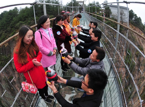 Marriage is proposed on an elevated walkway at Shiniuzhai Geological Park, Pingjiang, Hunan province, on Wednesday. XU XING/CHINA DAILY Marriage is proposed on an elevated walkway at Shiniuzhai Geological Park, Pingjiang, Hunan province, on Wednesday. XU XING/CHINA DAILY