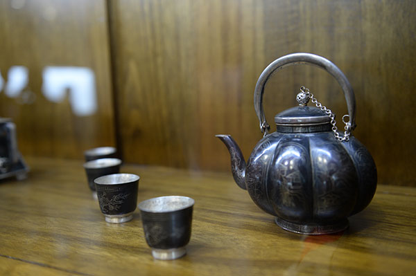 A tea set made by Silver-inlaid Black Copper is displayed in the learning center of Jin Yongcai, Nov 19, 2015. (Photo by Tan Qing/For chinadaily.com.cn) A tea set made by Silver-inlaid Black Copper is displayed in the learning center of Jin Yongcai, Nov 19, 2015. (Photo by Tan Qing/For chinadaily.com.cn)