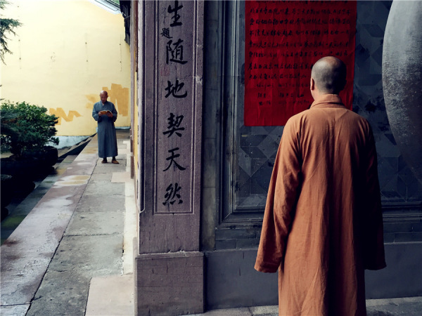 A monk is learning Buddhism while another reading a notice. (Photo: chinadaily.com.cn/Ruan Fan) A monk is learning Buddhism while another reading a notice. (Photo: chinadaily.com.cn/Ruan Fan)