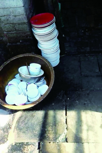 Bowls and dishes placed outdoors at the rice and chicken restaurant. (Photo/The Mirror) Bowls and dishes placed outdoors at the rice and chicken restaurant. (Photo/The Mirror)