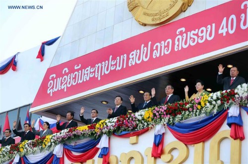 Zhang Dejiang (5th R), chairman of the Standing Committee of China's National People's Congress, and Lao President Choummaly Sayasone watch a parade marking the 40th anniversary of the founding of the Lao People's Democratic Republic, in Vientiane, Laos, Dec. 2, 2015. (Xinhua/Liu Weibing)