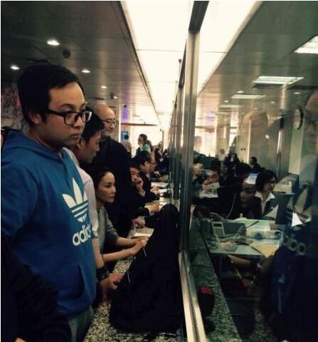 Faye Wong (C) sits in front of a counter at the Chaoyang Real Estate Registration Center on the afternoon of April 17. (File photo)