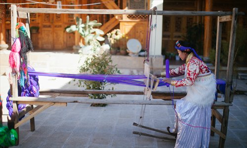 Shougong Geiru Yongqing weaves on a loom at her house. (Photo: Li Hao/GT) Shougong Geiru Yongqing weaves on a loom at her house. (Photo: Li Hao/GT)