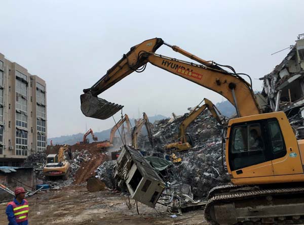 A rescue vehicle works on a debris of a factory building after a landslide occurred in Shenzhen. Strong signals of life have been detected on Monday. (Photo by Chai Hua/chinadaily.com.cn) A rescue vehicle works on a debris of a factory building after a landslide occurred in Shenzhen. Strong signals of life have been detected on Monday. (Photo by Chai Hua/chinadaily.com.cn)