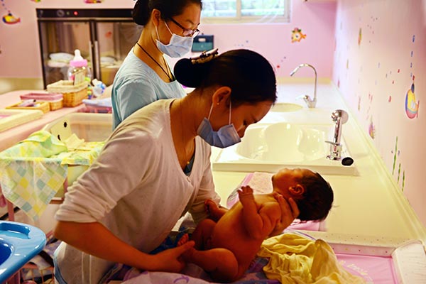 A nurse tends to a newborn after giving the infant a bath at the Heyi Confinement Center in Xiamen, Fujian province. (Photo/China Daily) A nurse tends to a newborn after giving the infant a bath at the Heyi Confinement Center in Xiamen, Fujian province. (Photo/China Daily)