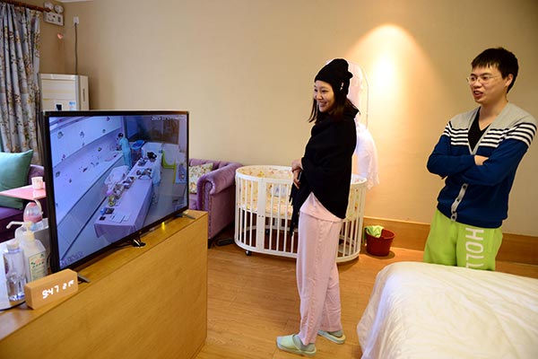 A couple watch their newborn on a TV screen at the Heyi Confinement Center in Xiamen, Fujian province. The center takes in only 20 pairs of mothers and babies at a time and charges 48,000 yuan ($7,400) to 198,000 yuan per month. (Photo/China Daily) A couple watch their newborn on a TV screen at the Heyi Confinement Center in Xiamen, Fujian province. The center takes in only 20 pairs of mothers and babies at a time and charges 48,000 yuan ($7,400) to 198,000 yuan per month. (Photo/China Daily)