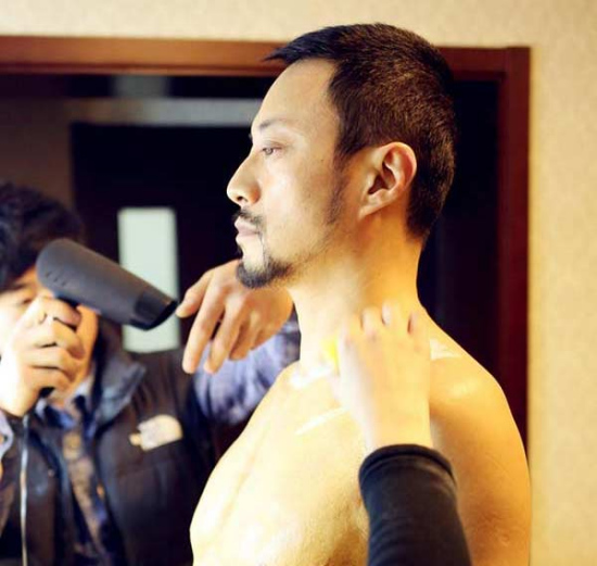 Special effects artists are pasting fake muscles on the chest of award-winning actor Zhang Hanyu so as to help him play the supporting role of Men Saner in Mr. Six. (Photo/Weibo) Special effects artists are pasting fake muscles on the chest of award-winning actor Zhang Hanyu so as to help him play the supporting role of Men Saner in Mr. Six. (Photo/Weibo)