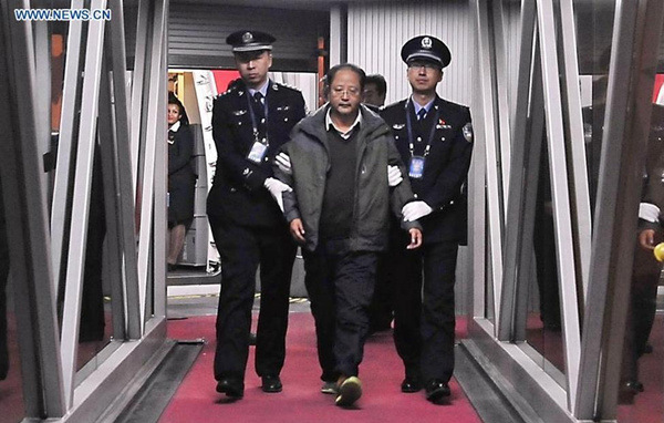 Pei Jianqiang, one of China's most wanted economic fugutives, is escorted by policemen at Capital International Airport in Beijing, capital of China, Jan. 1, 2016. Fleeing abroad in 2009, the 48-year-old former manager of China International Enterprises Cooperative's import and export department is one of the 100 economic suspects on a list wanted worldwide by the Interpol's National Central Bureau of China, including 77 men and 23 women allegedly involved in corruption. The list is part of China's Sky Net campaign to repatriate corruption suspects fleeing overseas. (Photo: Xinhua/Li Xin) Pei Jianqiang, one of China's most wanted economic fugutives, is escorted by policemen at Capital International Airport in Beijing, capital of China, Jan. 1, 2016. Fleeing abroad in 2009, the 48-year-old former manager of China International Enterprises Cooperative's import and export department is one of the 100 economic suspects on a list wanted worldwide by the Interpol's National Central Bureau of China, including 77 men and 23 women allegedly involved in corruption. The list is part of China's Sky Net campaign to repatriate corruption suspects fleeing overseas. (Photo: Xinhua/Li Xin)