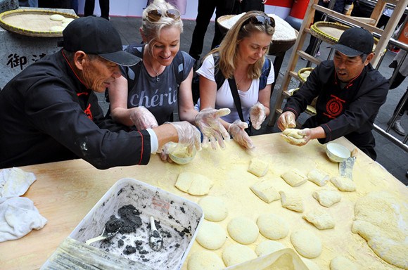 Tourists learn to make ciba, a traditional form of glutinous rice cake, during a Chinese snack food festival in Shanghai in November. (Photo: China Daily/Zhou Dongchao) Tourists learn to make ciba, a traditional form of glutinous rice cake, during a Chinese snack food festival in Shanghai in November. (Photo: China Daily/Zhou Dongchao)
