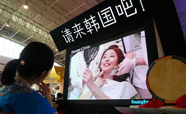 A visitor watches a South Korean plastic surgery promotional film at an international travel expo in Beijing.(Photo provided to China Daily) A visitor watches a South Korean plastic surgery promotional film at an international travel expo in Beijing.(Photo provided to China Daily)