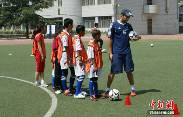 A coach from Real Madrid teaches children soccer in Lanzhou, Gansu province in June 2014. (File photo/Chinanews.com) A coach from Real Madrid teaches children soccer in Lanzhou, Gansu province in June 2014. (File photo/Chinanews.com)