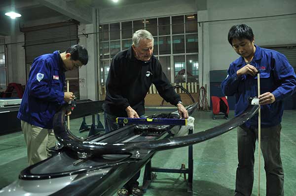 Klaus Filter instructs Chinese workers at Sino Eagle Group, a leading manufacturer of rowing shells in Fuyang, Zhejiang province. The German designer is a witness-and a major contributor-to the company's growth over the past two decades.(Photo: China Daily/Liu Xiangrui)