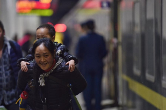A woman carries a child to a train at Shenzhen, South China's Guangdong province, heading for Chengdu, Southwest China's Sichuan province, Jan 24, 2016. (Photo/Xinhua) A woman carries a child to a train at Shenzhen, South China's Guangdong province, heading for Chengdu, Southwest China's Sichuan province, Jan 24, 2016. (Photo/Xinhua)
