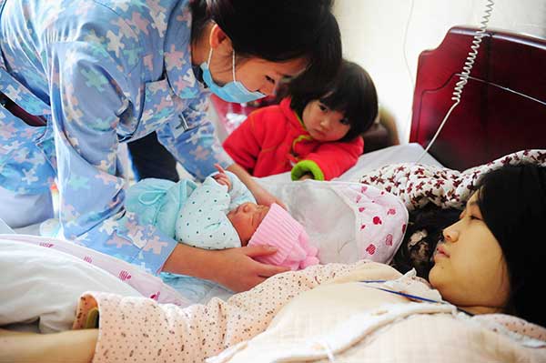 Six-year-old Xu Yuechen looks at her baby brother by the bed of her mother at a maternity hospital in Fuyang, Anhui province. (Photo: China Daily/Wang Biao) Six-year-old Xu Yuechen looks at her baby brother by the bed of her mother at a maternity hospital in Fuyang, Anhui province. (Photo: China Daily/Wang Biao)
