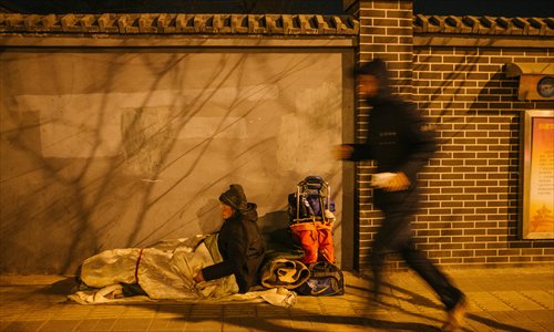 A man runs past a homeless person near Beijing South Railway Station on January 22, one of the coldest days this winter.(Photo: Global Times/Li Hao) A man runs past a homeless person near Beijing South Railway Station on January 22, one of the coldest days this winter.(Photo: Global Times/Li Hao)