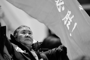 Li holds a banner at the stadium, with two Chinese national flags painted on her cheeks. (Photo/www.tlnews.cn) Li holds a banner at the stadium, with two Chinese national flags painted on her cheeks. (Photo/www.tlnews.cn)