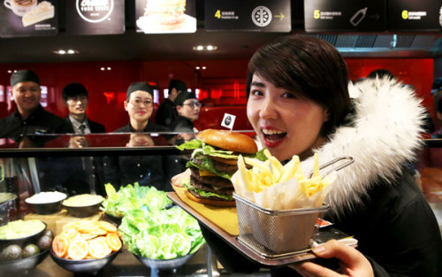 A customer shows a self-made burger at McDonald's first Experience of the Future restaurant in Beijing.(Photo/China Daily) A customer shows a self-made burger at McDonald's first Experience of the Future restaurant in Beijing.(Photo/China Daily)