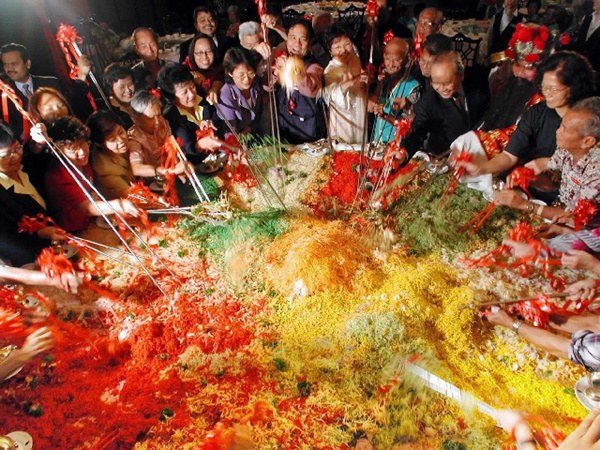 Yu Sheng, or Yee Sang, is a traditional food ritual during the Lunar New Year. Diners toss ingredients high in the air to wish for luck and happiness. (Photo/Xinhua) Yu Sheng, or Yee Sang, is a traditional food ritual during the Lunar New Year. Diners toss ingredients high in the air to wish for luck and happiness. (Photo/Xinhua)