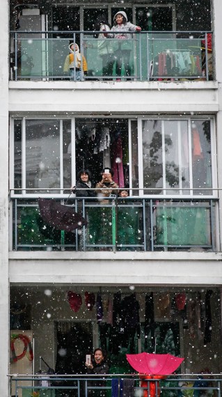 Residents enjoy the snow from their balconies in Panyu, Guangdong province, on Sunday. (Photo: China Daily/Chen Zhigang) Residents enjoy the snow from their balconies in Panyu, Guangdong province, on Sunday. (Photo: China Daily/Chen Zhigang)