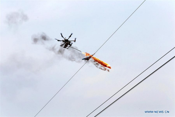 A drone burns off waste and sundries on the wire in Puyang, Central China's Henan province, March 17, 2015. (Photo/Xinhua) A drone burns off waste and sundries on the wire in Puyang, Central China's Henan province, March 17, 2015. (Photo/Xinhua)