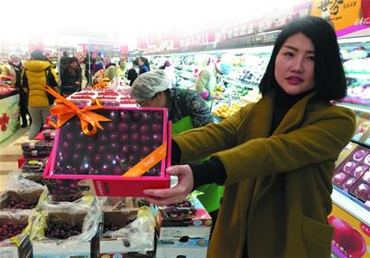 A woman holds a box of foreign fruits in a supermarket of Qingdao. (Photo/Qingdaonews.com) A woman holds a box of foreign fruits in a supermarket of Qingdao. (Photo/Qingdaonews.com)