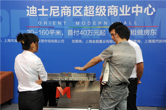 Two sales people introduce a housing project to a potential buyer at a Disney commercial property promotion event.(Photo/China Daily) Two sales people introduce a housing project to a potential buyer at a Disney commercial property promotion event.(Photo/China Daily)