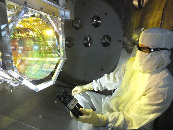 A technician inspects one of the U.S. laboratory's core optics (mirrors) by illuminating its surface at different angles. Caltech/MIT/LIGO Lab A technician inspects one of the U.S. laboratory's core optics (mirrors) by illuminating its surface at different angles. Caltech/MIT/LIGO Lab