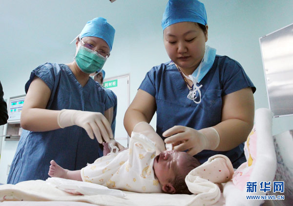 Medical staff put clothes on the newborn test-tube baby at a hospital in Xi'an, Northwest China's Shaanxi province. (Photo/Xinhua) Medical staff put clothes on the newborn test-tube baby at a hospital in Xi'an, Northwest China's Shaanxi province. (Photo/Xinhua)