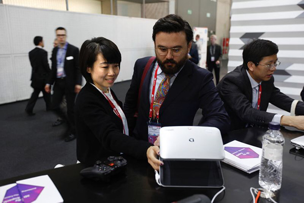A member of SuperD Co Ltd staff demonstrates the company's glass-free 3D device to a visitor to the Mobile World Congress, Feb 25, 2016. (Photo provided to chinadaily.com.cn A member of SuperD Co Ltd staff demonstrates the company's glass-free 3D device to a visitor to the Mobile World Congress, Feb 25, 2016. (Photo provided to chinadaily.com.cn