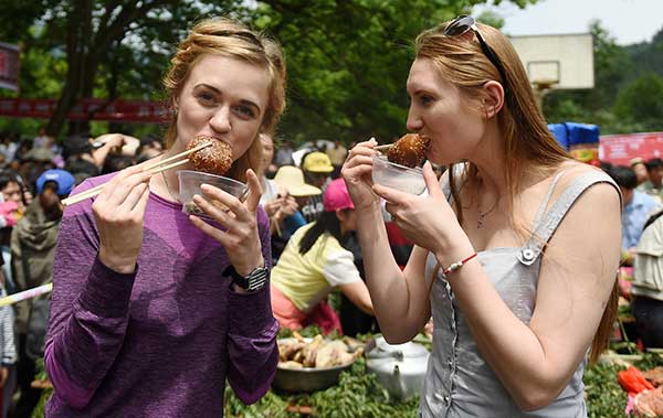 Two visitors from Russia taste local snacks in Rongshui, Guangxi Zhuang autonomous region.(Photo/Xinhua) Two visitors from Russia taste local snacks in Rongshui, Guangxi Zhuang autonomous region.(Photo/Xinhua)