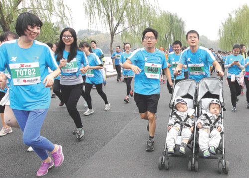 A man runs with his twin sons on the 2014 Hangzhou Marathon. (China Daily/Xu Kangping) A man runs with his twin sons on the 2014 Hangzhou Marathon. (China Daily/Xu Kangping)