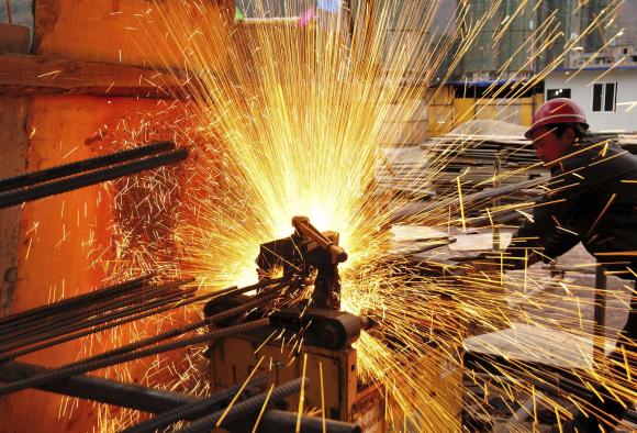 A worker welds at a construction site in Yiliang, Yunnan province, Feb 28, 2015.(Photo/Agencies)